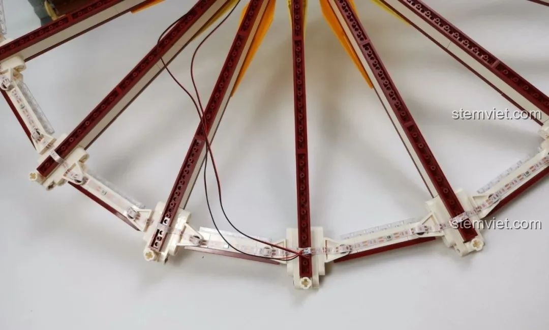 Dây đèn LED được lắp đặt dọc theo các nan hoa của bánh xe Vòng Quay Khổng Lồ Mould King 11006.