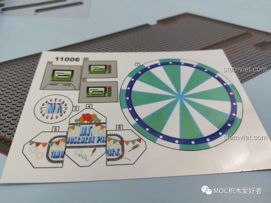 Tấm dán sticker với các họa tiết trang trí cho Vòng Quay Khổng Lồ Mould King 11006, bao gồm bảng hiệu và vòng tròn.