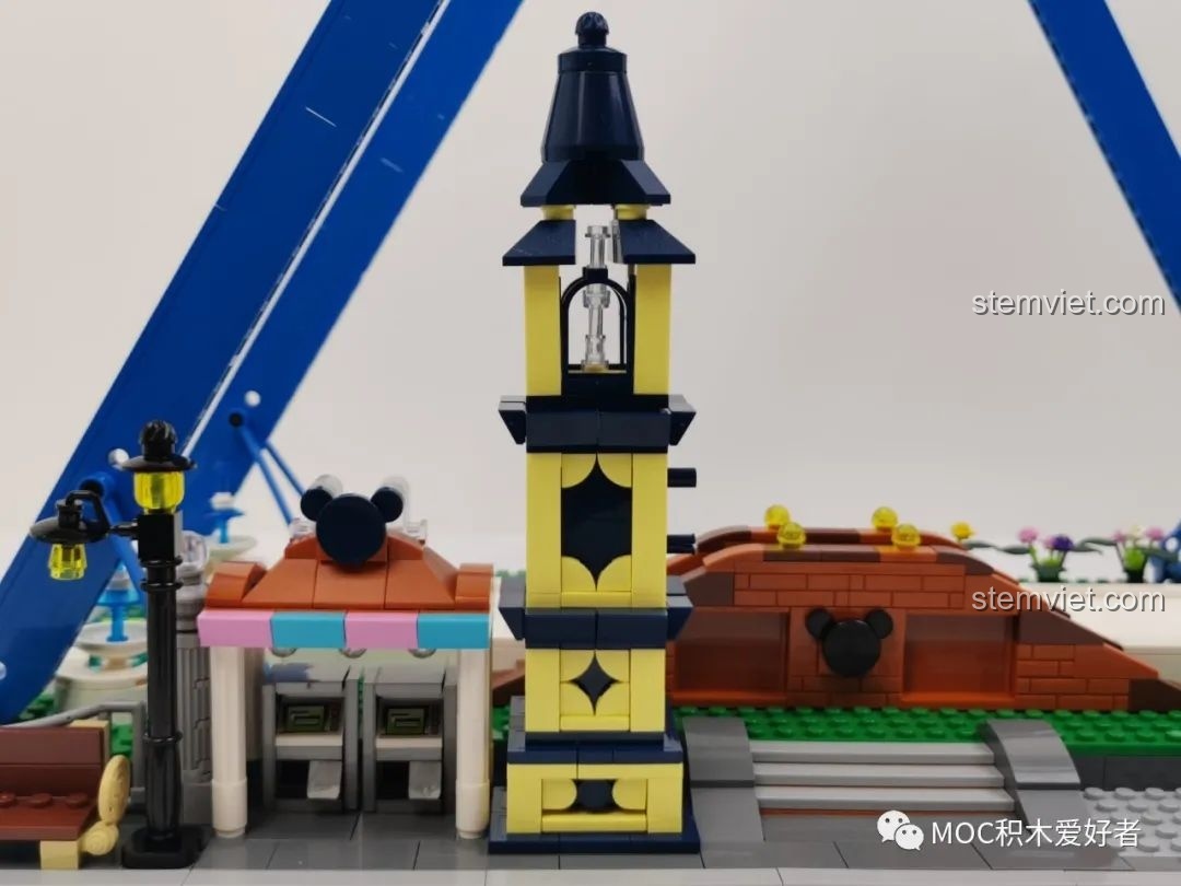 Tháp đồng hồ màu vàng và xanh đen, một phần của khu vực cổng vào Vòng Quay Khổng Lồ Mould King 11006.