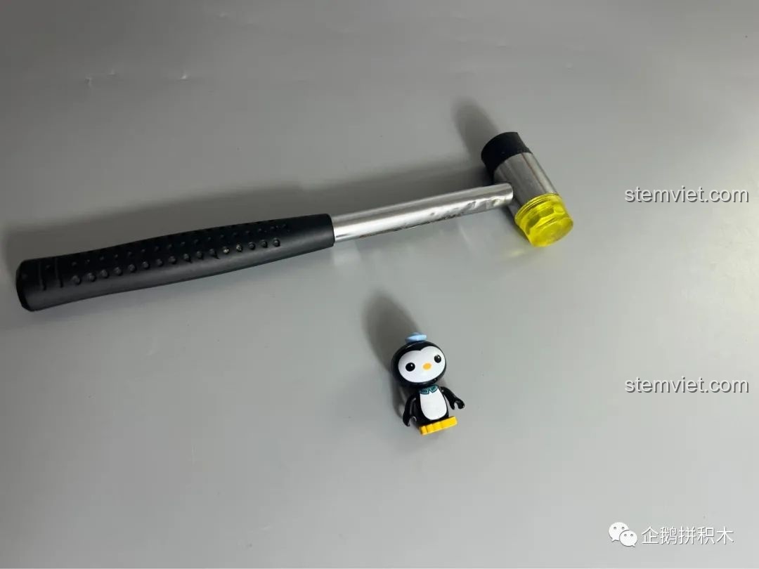 Chiếc búa nhỏ màu vàng đi kèm bộ lắp ráp Tàu Thiên Niên Kỷ Mould King 21026, một công cụ hữu ích để lắp các mảnh ghép chặt chẽ.