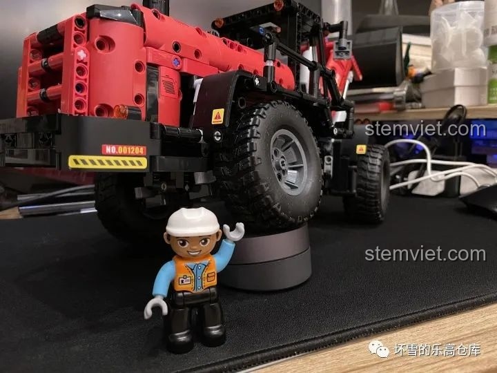 Nhân vật minifig đứng cạnh mô hình Xe Xúc Lật Công Trình ONEBOT OBZZJ01AIQI, thể hiện sự hài lòng với sản phẩm.