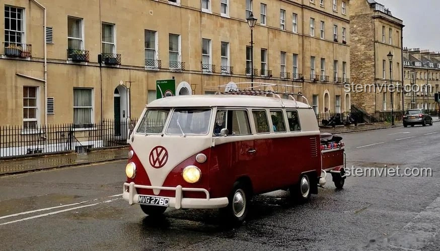 Hình ảnh xe Volkswagen T1 Campervan màu đỏ trắng cổ điển trên đường, biểu tượng của những chuyến đi tự do, gợi cảm hứng cho bộ lắp ghép Pinbo PB8807 Xe Cắm Trại T1.