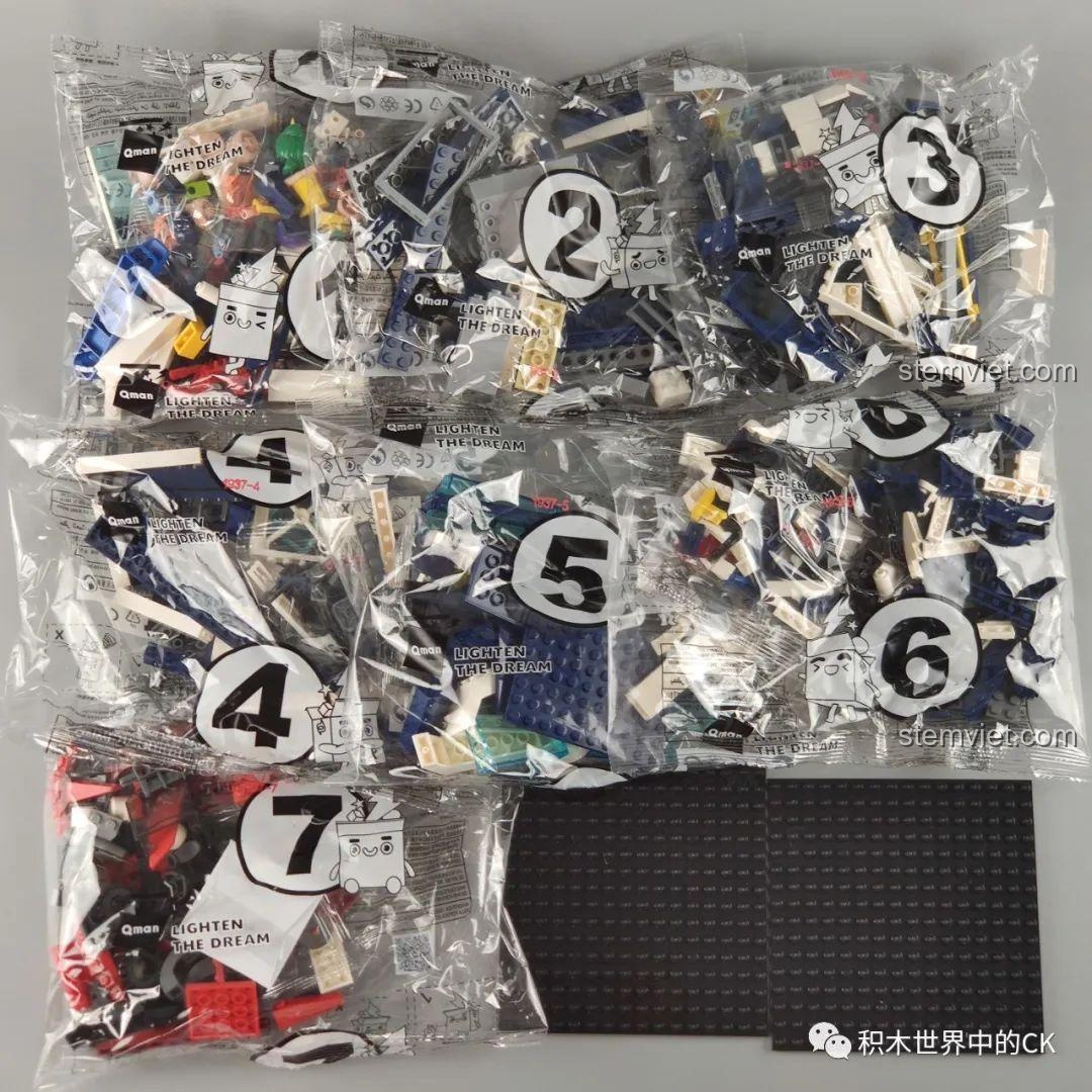 Các túi mảnh ghép được đánh số từ 1 đến 7 và một tấm đế lớn, chuẩn bị cho việc lắp ráp bộ Sở Cảnh Sát Trọng Án Qman 1937.