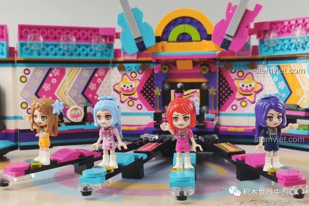 Cận cảnh hai cây đàn guitar mini màu xanh và hồng trên sân khấu của bộ QMAN 2031.