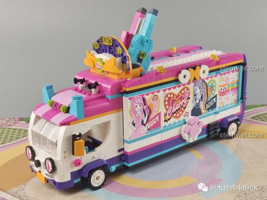 Mô hình xe buýt QMAN 2031 Xe Buýt Sân Khấu nhìn từ bên hông, với các sticker nhân vật và logo Cherry.