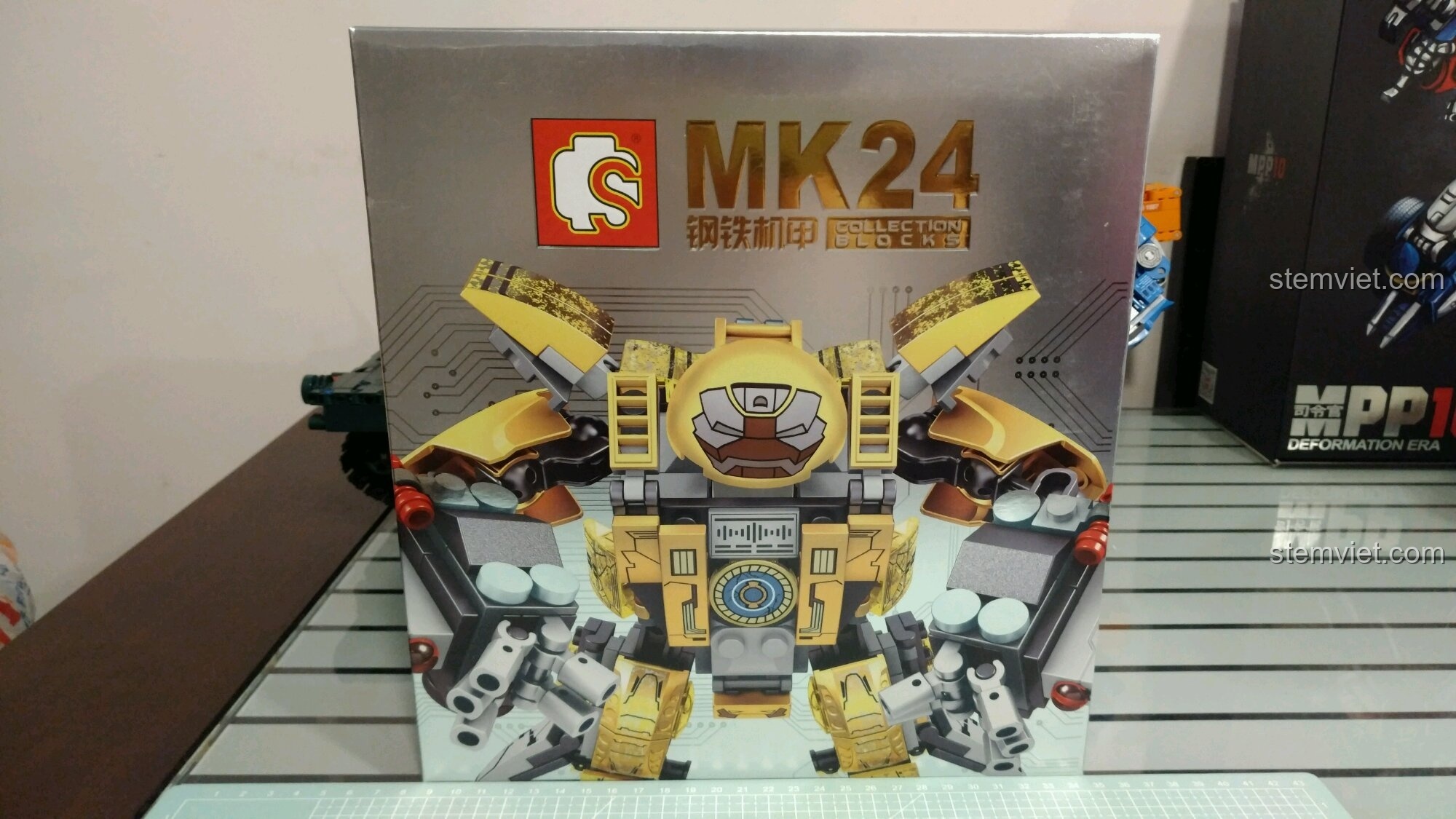 Mặt trước hộp đồ chơi Sembo 3 Mecha chiến đấu MK24 với hình ảnh robot màu vàng gold nổi bật, phù hợp cho bé trai 6 tuổi.