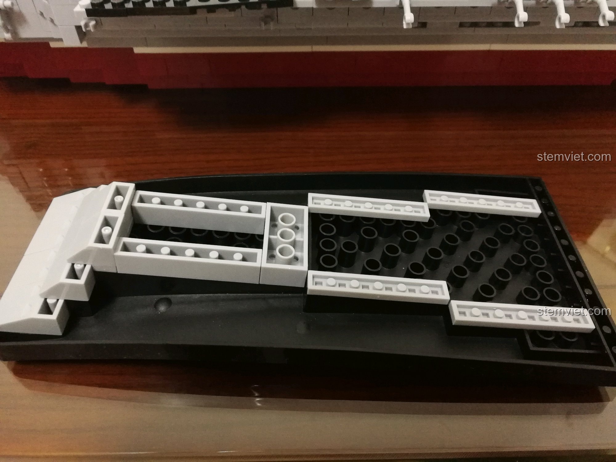 Toàn bộ phần boong tàu màu đen của bộ lắp ráp Sluban 399 Mô hình tàu sân bay Liêu Ninh đã được lắp đặt lên thân tàu, tạo nên bề mặt sân bay rộng lớn và uy lực.