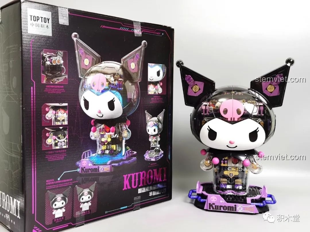 Mô hình Kuromi bán cơ khí TOP TOY TC1803 phiên bản cầu vồng trưng bày trên bàn cạnh cây xanh, tạo không gian thư giãn.