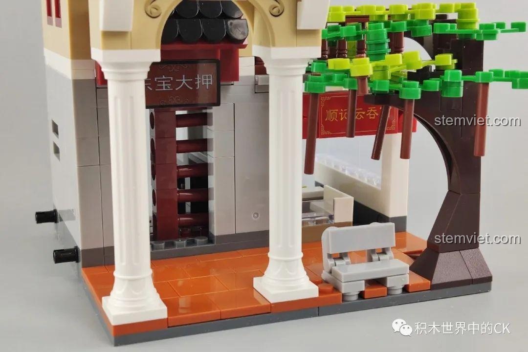 Chi tiết cây xanh và băng ghế đá trước mô hình WOMA C0338 Khu Phố Cổ Qilou, tạo không gian xanh mát. Phụ kiện cảnh quan.