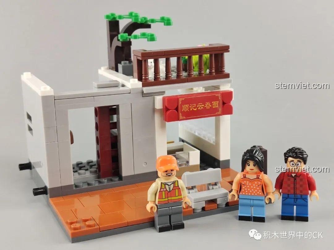 Phần đế của mô hình WOMA C0338 Khu Phố Cổ Qilou đang được xây dựng, kèm theo ba minifigure. Bước đầu tiên của quá trình lắp ráp.