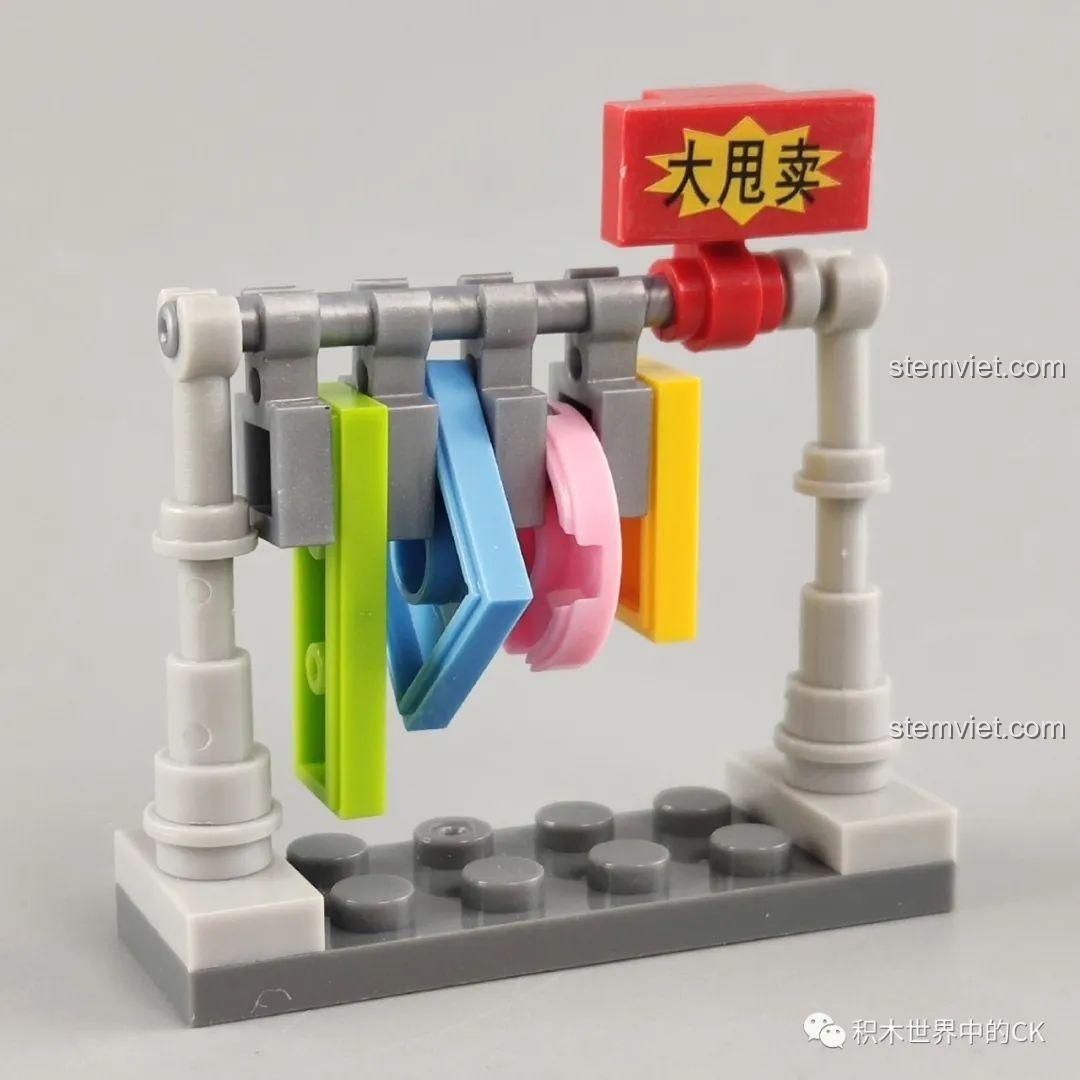 Kệ treo quần áo với các bộ trang phục nhiều màu sắc, phụ kiện của bộ lắp ghép WOMA C0338 Khu Phố Cổ Qilou. Đồ chơi trang trí.