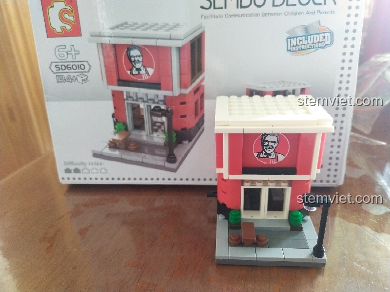 Mô hình Cửa hàng Gà Rán KFC Sembo SD6010 hoàn chỉnh đặt cạnh hộp sản phẩm, sẵn sàng để trưng bày.