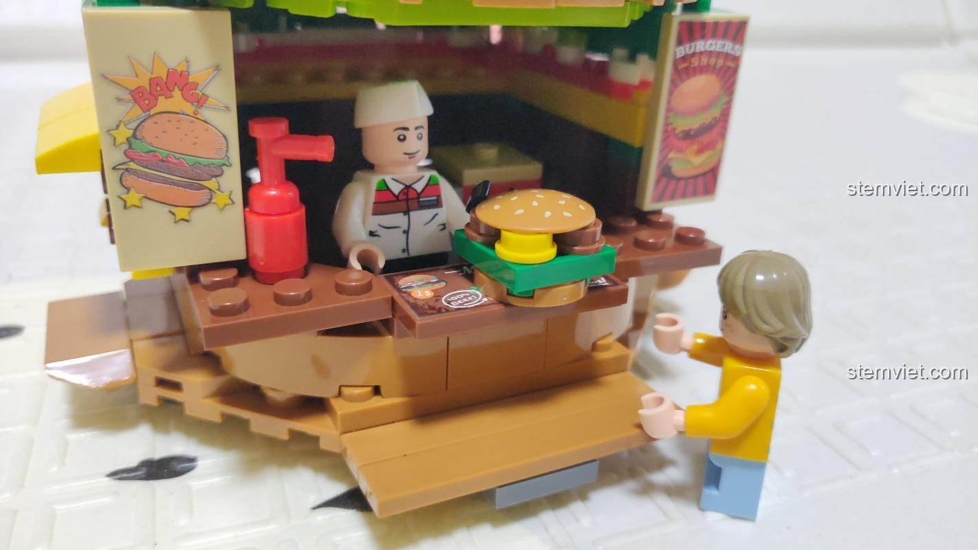 Chi tiết minifigure đầu bếp và khách hàng trong đồ chơi mô hình Sembo 601055. Người đầu bếp đang phục vụ một chiếc hamburger.