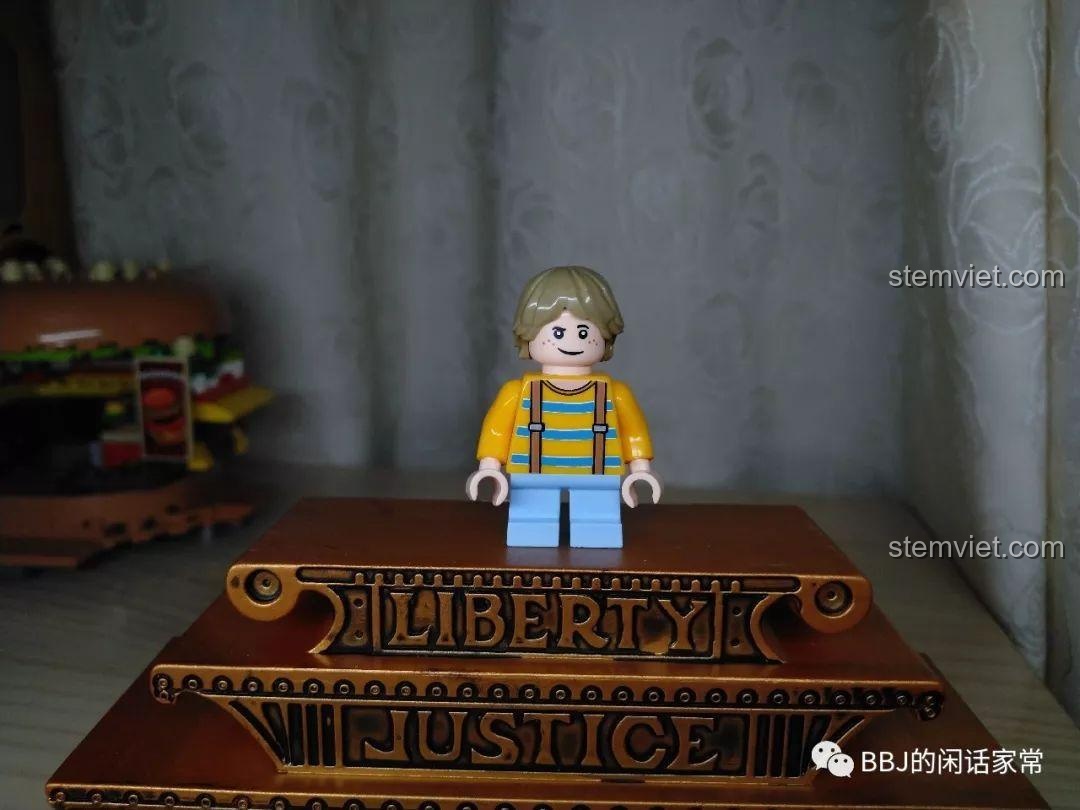 Minifigure khách hàng nhí trong bộ đồ chơi Cửa hàng đồ ăn nhanh Sembo, mặc áo vàng và quần xanh.