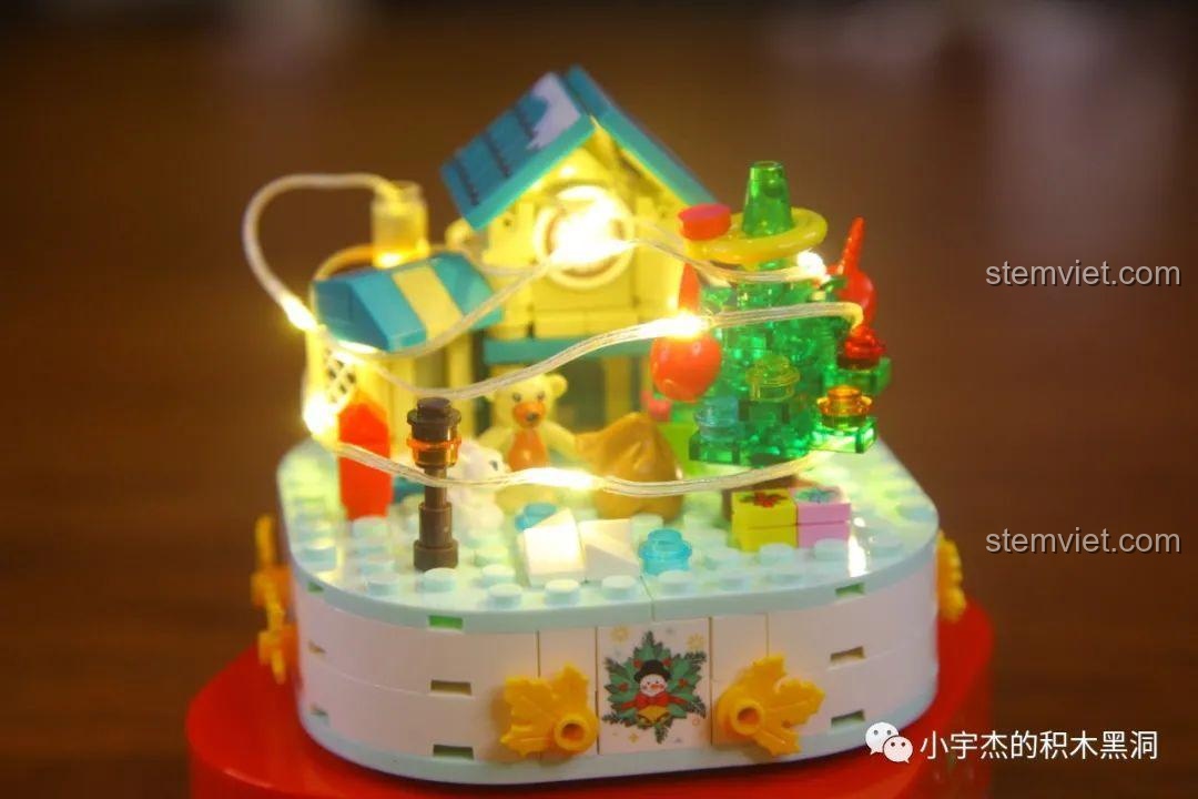 Quấn dây đèn LED quanh mô hình nhà và cây thông trong bộ Sembo 601162.