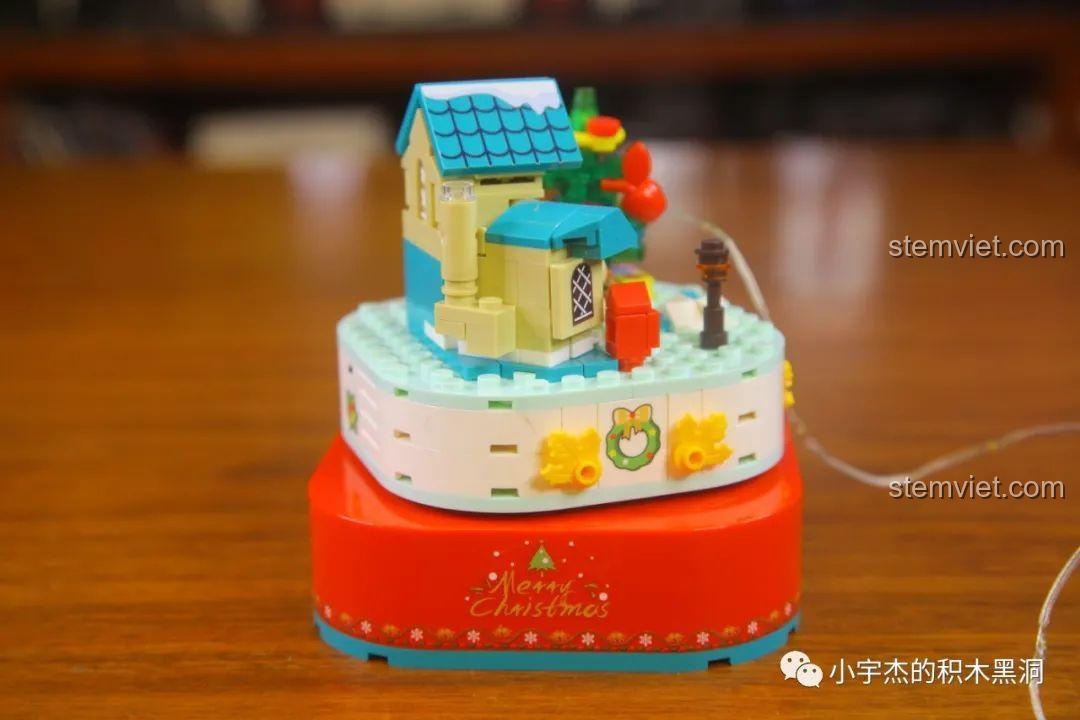 Mô hình cảnh Giáng sinh bên trong hộp nhạc Sembo 601162 đang được lắp ráp.