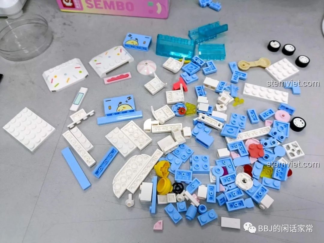 Toàn bộ các mảnh ghép màu xanh, trắng, hồng và vàng của bộ lắp ráp SEMBO 615004 Xe Kem Que Băng Tinh được đổ ra.