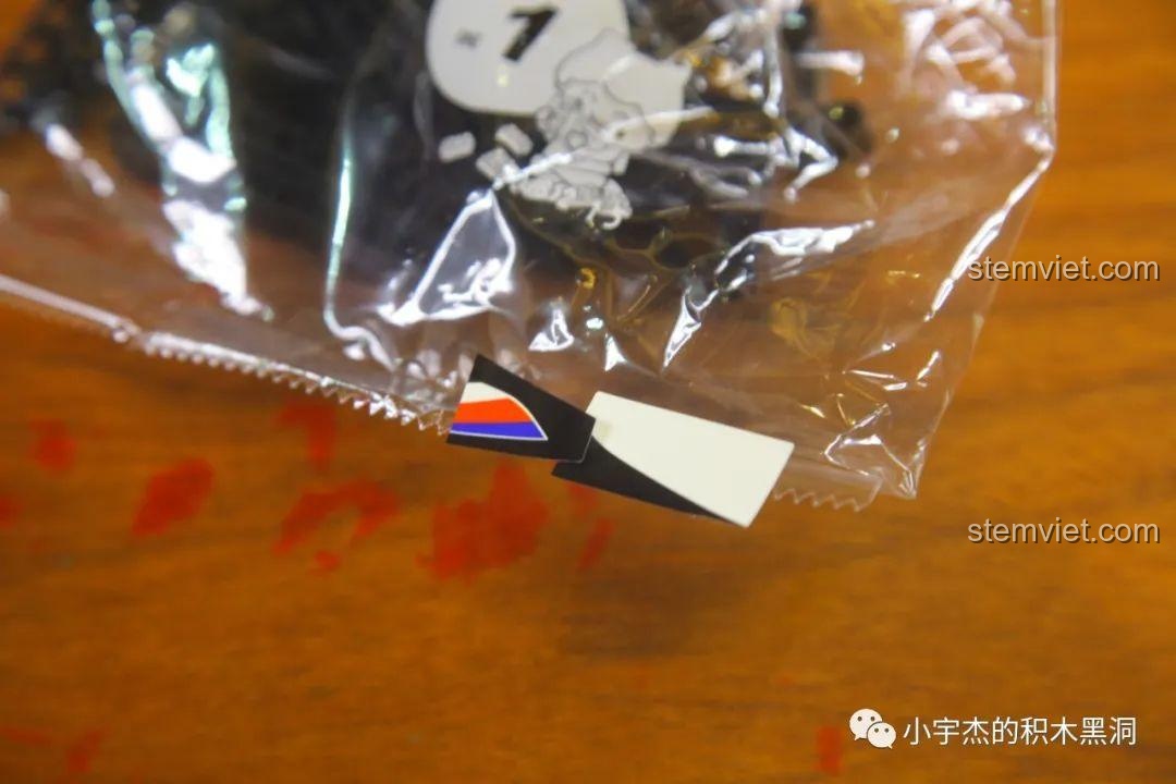 Cận cảnh miếng sticker bị dính ra ngoài túi mảnh ghép của bộ lắp ráp SEMBO 701812, cho thấy cần kiểm tra kỹ khi mở hộp.