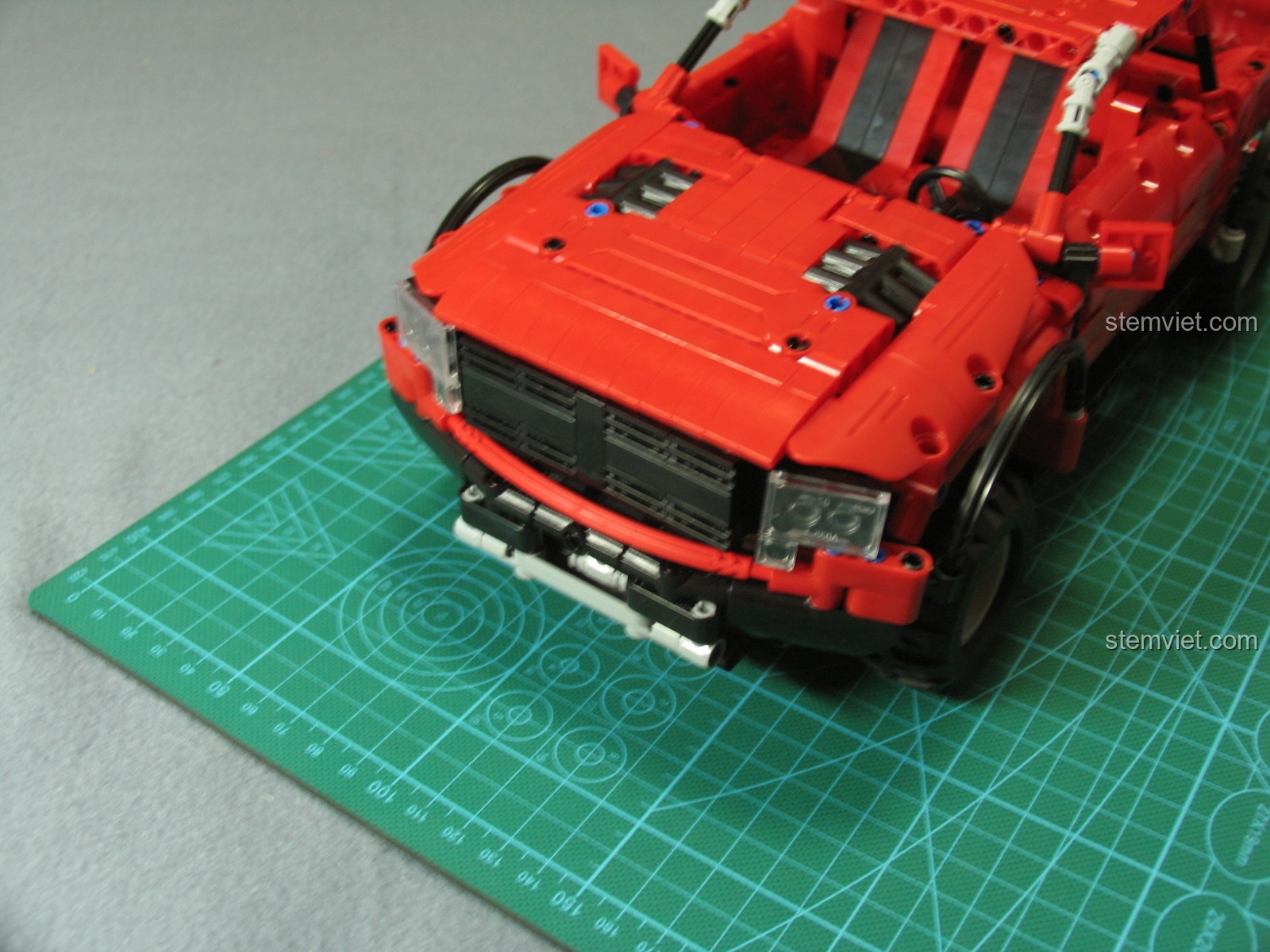 So sánh xe bán tải CaDA C51005 với mô hình xe 1:64 từ góc phía trước, làm nổi bật sự khác biệt về kích thước và chi tiết.