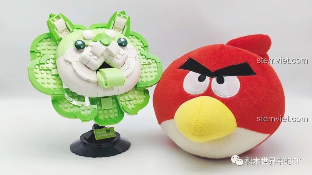 So sánh kích thước của mô hình Chó Bắp Cải Mr.Kuriosity 12601 với một chú gấu bông Angry Bird màu đỏ.