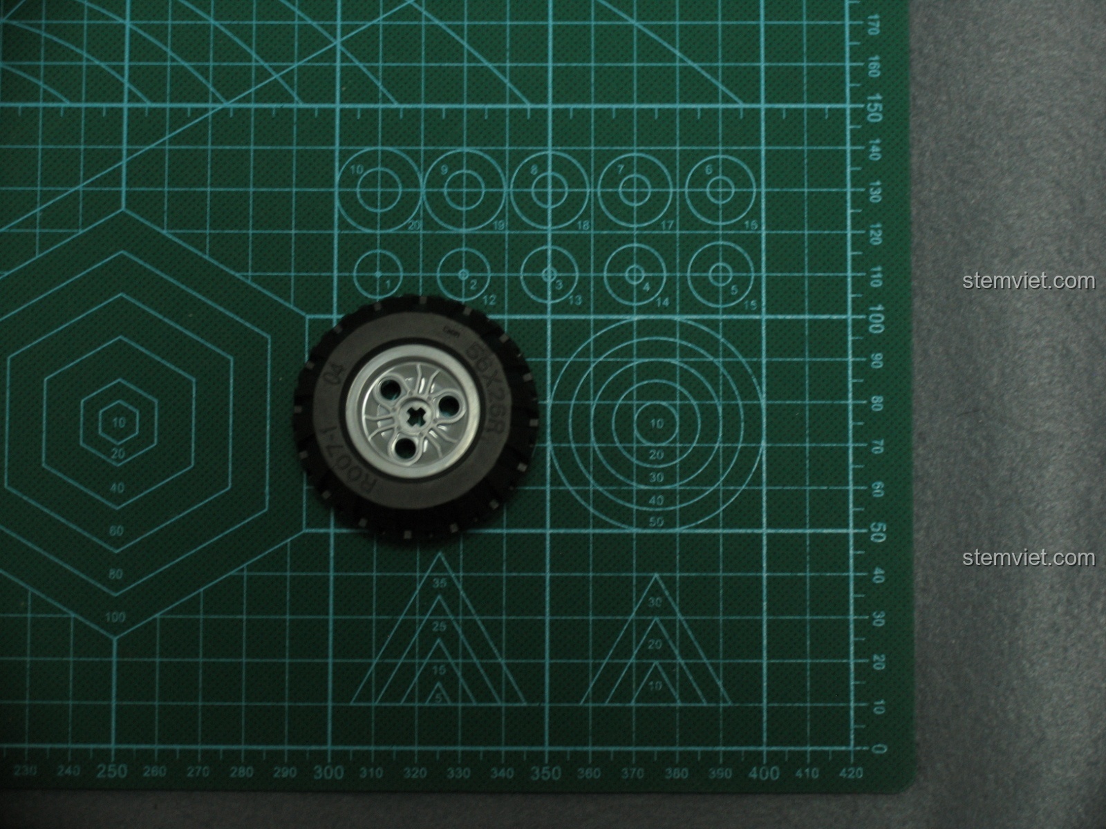 Hình ảnh lốp xe CaDA C51005 đặt trên thước đo, cho thấy kích thước thực tế của bánh xe trước khi lắp ráp.