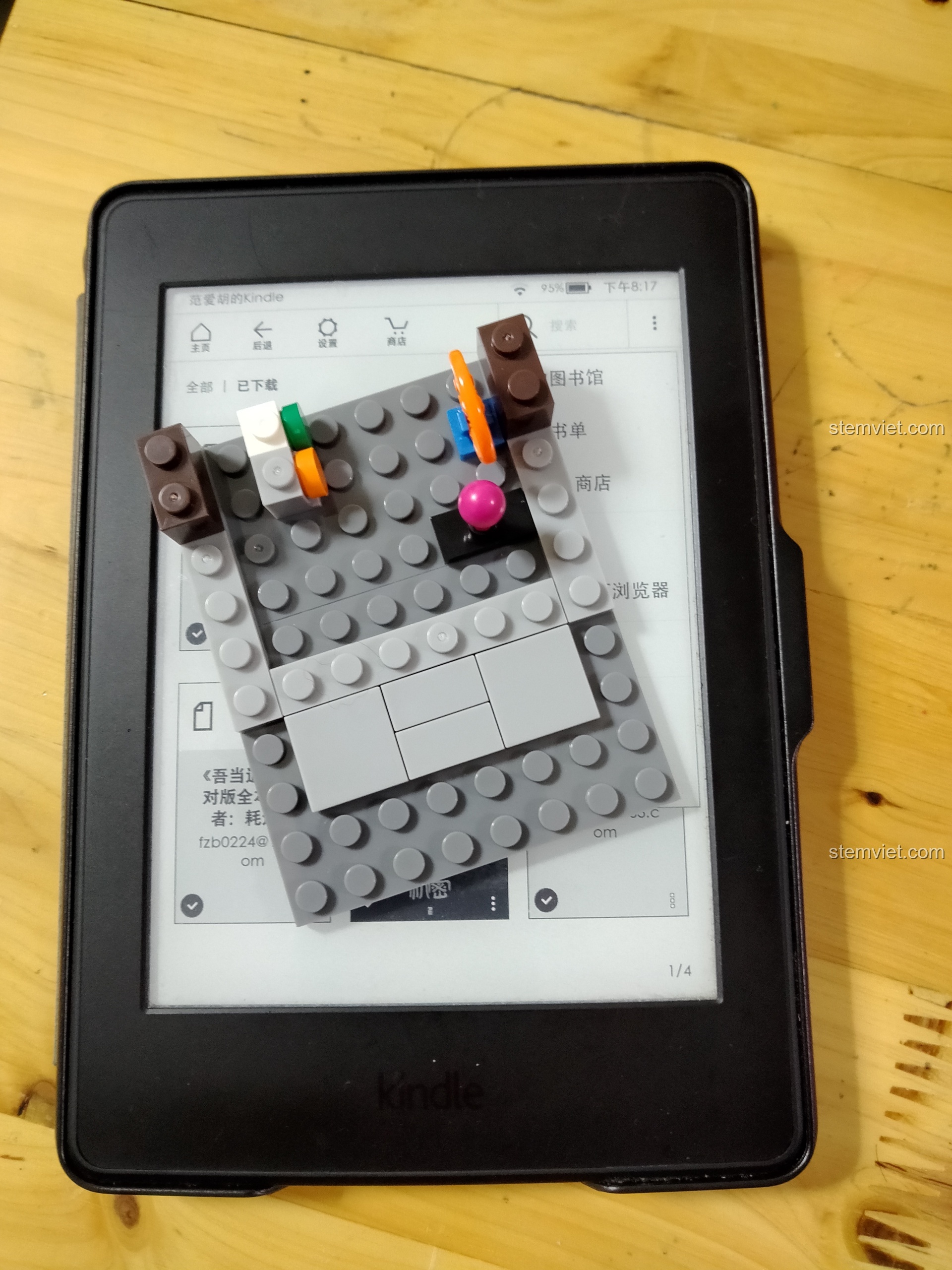 So sánh kích thước của phần đế mô hình Sembo 6022 với một chiếc máy đọc sách Kindle để thấy độ nhỏ gọn.