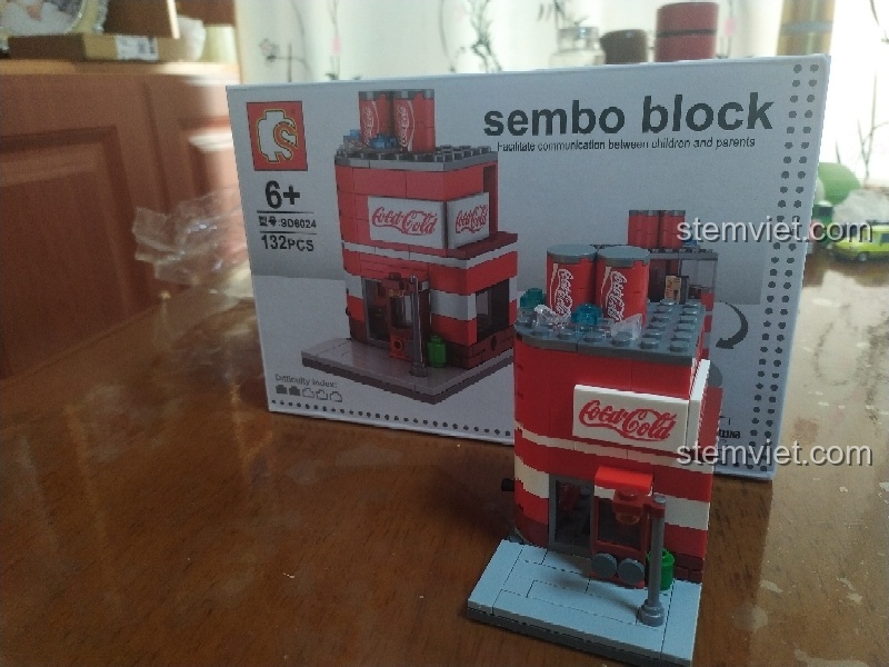 So sánh mô hình Cửa hàng nước ngọt Coca-Cola SD6024 đã lắp xong và vỏ hộp sản phẩm.