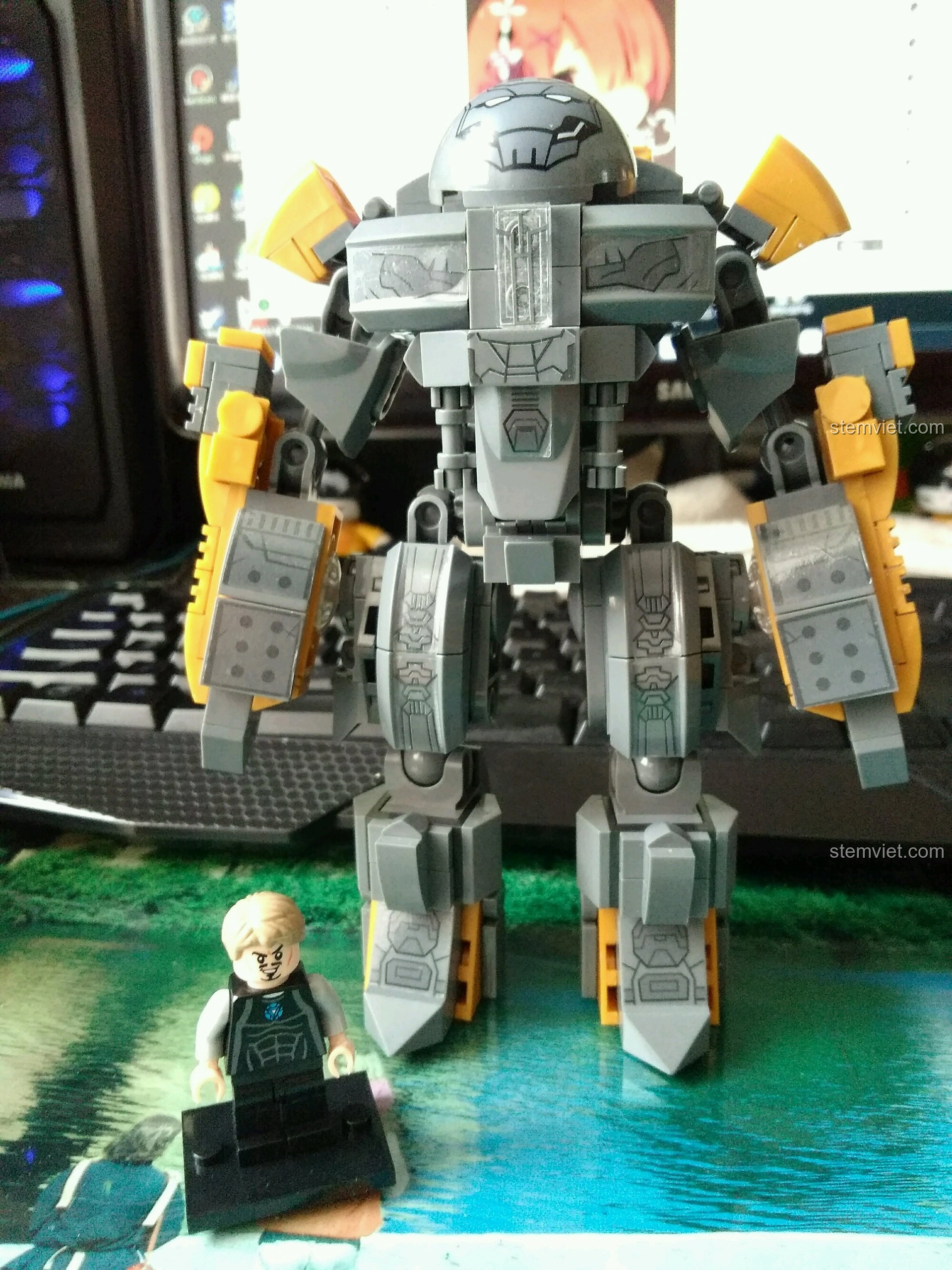 Mô hình SY MK25 Giáp Anti-Hulk Mecha và minifigure Tony Stark trên bàn làm việc, cho thấy kích thước và khả năng trưng bày thực tế.