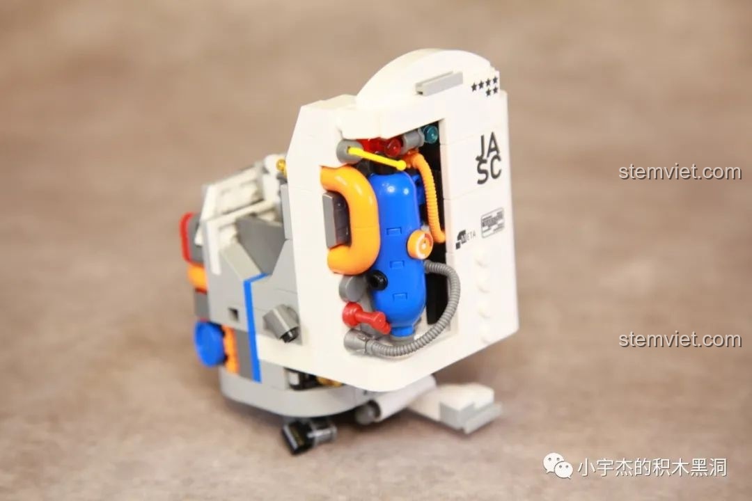 Góc nhìn nghiêng của phần thân mô hình Phi hành gia JAKI JK9106, chi tiết máy móc đầy màu sắc.