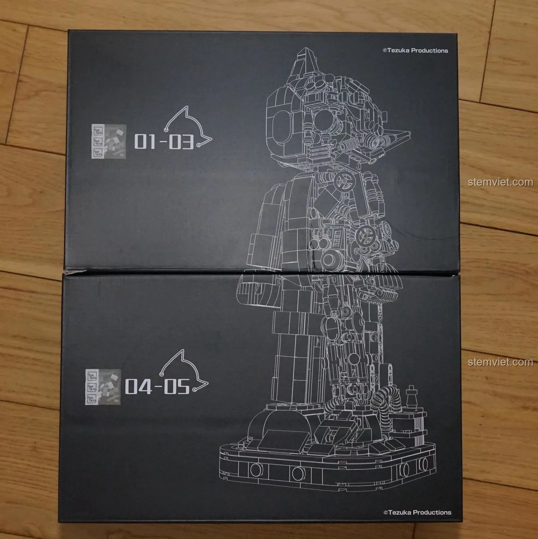 Hai hộp đựng chi tiết bên trong của bộ Pantasy 86203, khi ghép lại tạo thành hình ảnh line-art của Astro Boy.