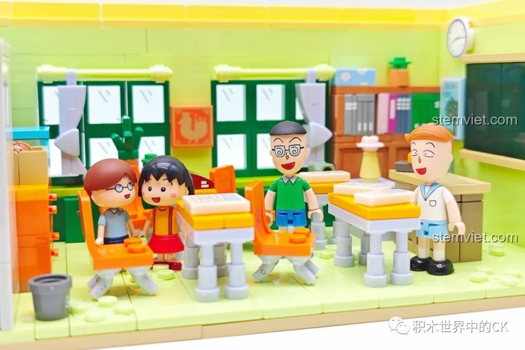 Các nhân vật Maruko, Maruo, Tama-chan và Hanawa đứng trước mô hình trường học Wekki 516412.