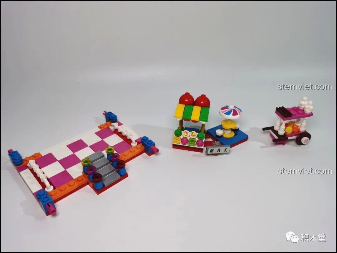 Xe kem và cửa hàng nhỏ cùng nền tảng được lắp ráp từ bộ đồ chơi Yunri 66111 Mô Hình Vòng Quay Ferris Wheel, tạo cảnh quan vui nhộn.