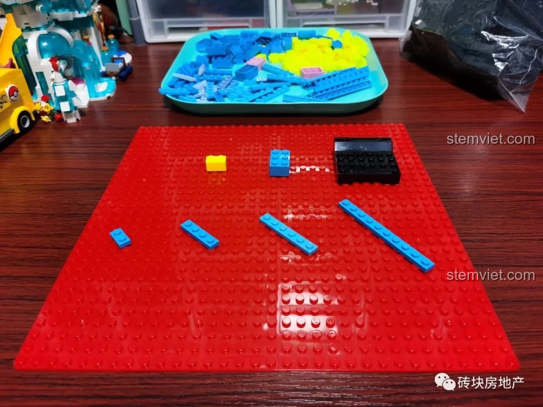 Các mảnh ghép màu xanh dương và vàng được xếp trên đế lắp ráp, tạo hình bậc thang cho hộp trưng bày.