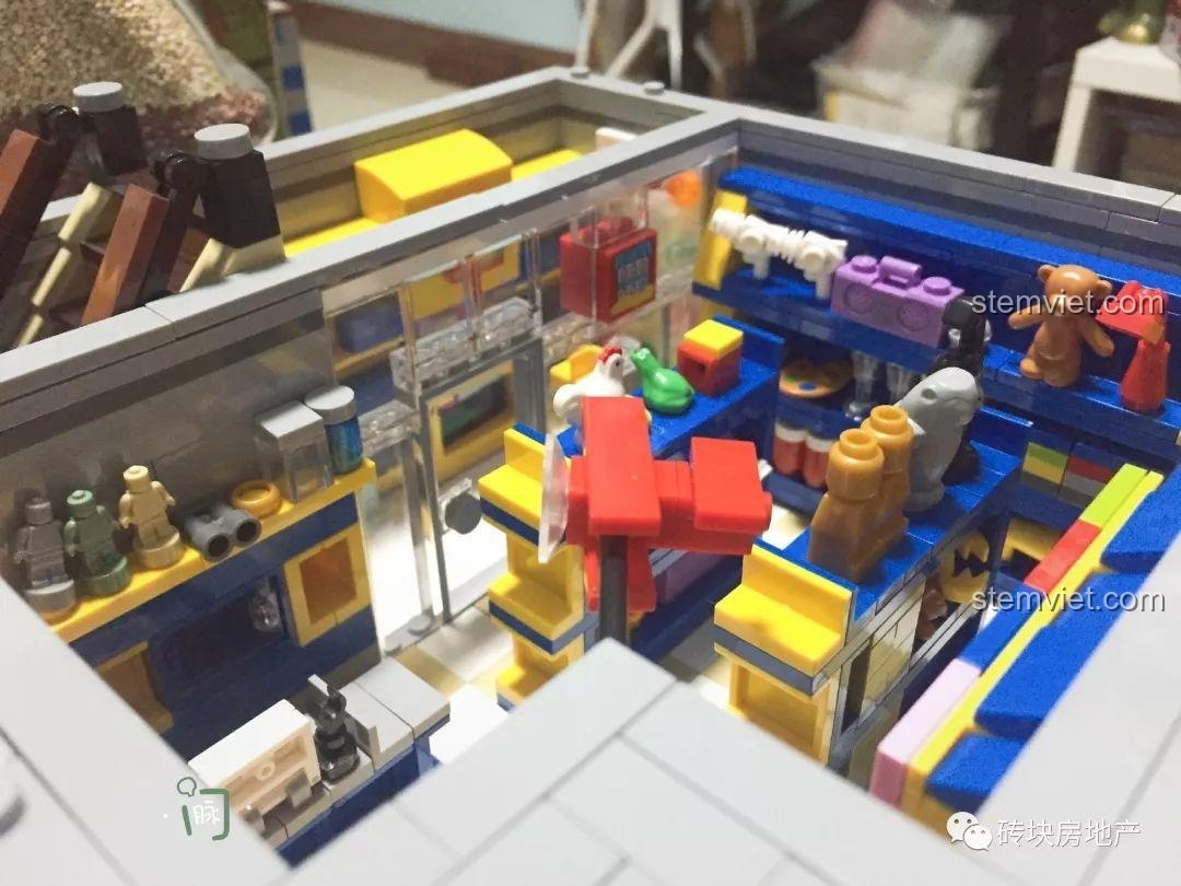 Nội thất chi tiết tầng 1 của đồ chơi mô hình Xingbao 01006, cửa hàng đồ chơi với nhiều kệ hàng.