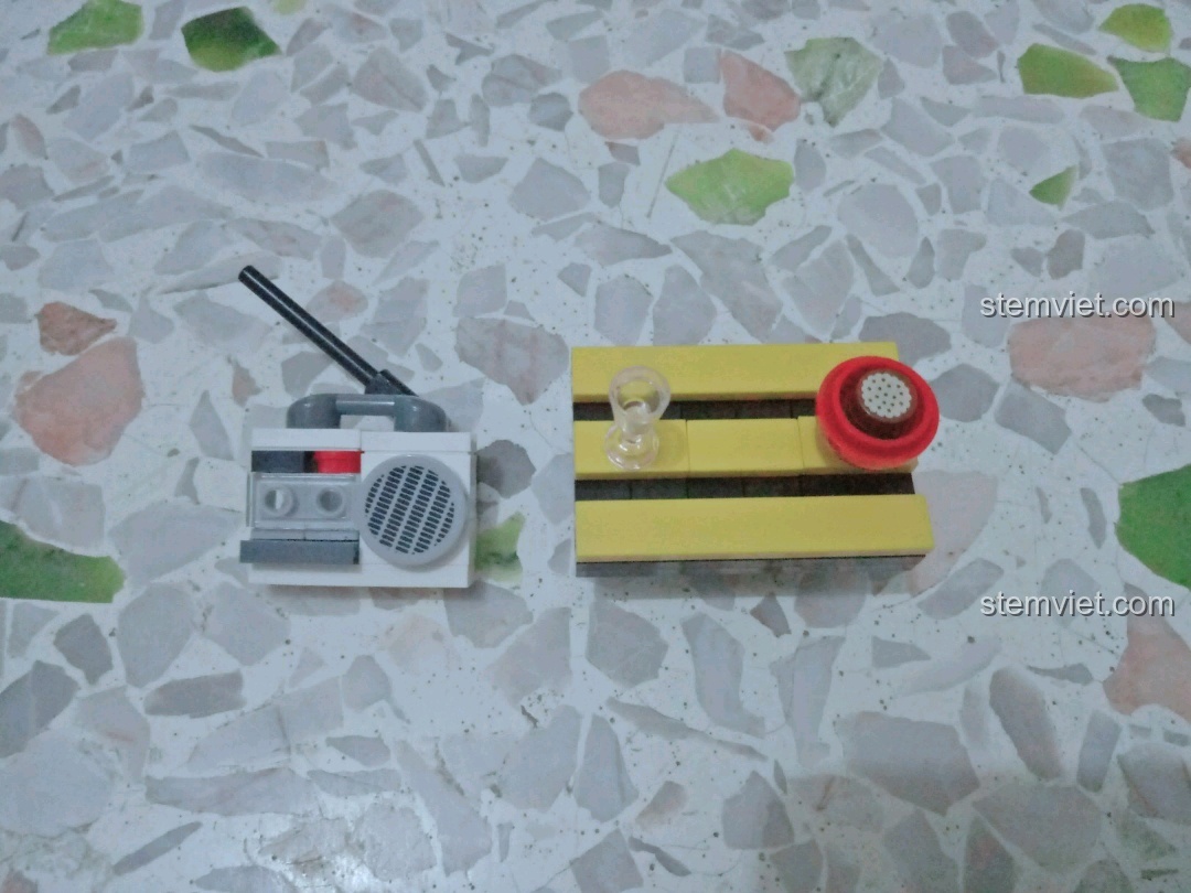 Cảnh cắm trại hoàn chỉnh với cây dừa, ghế, bàn và radio.