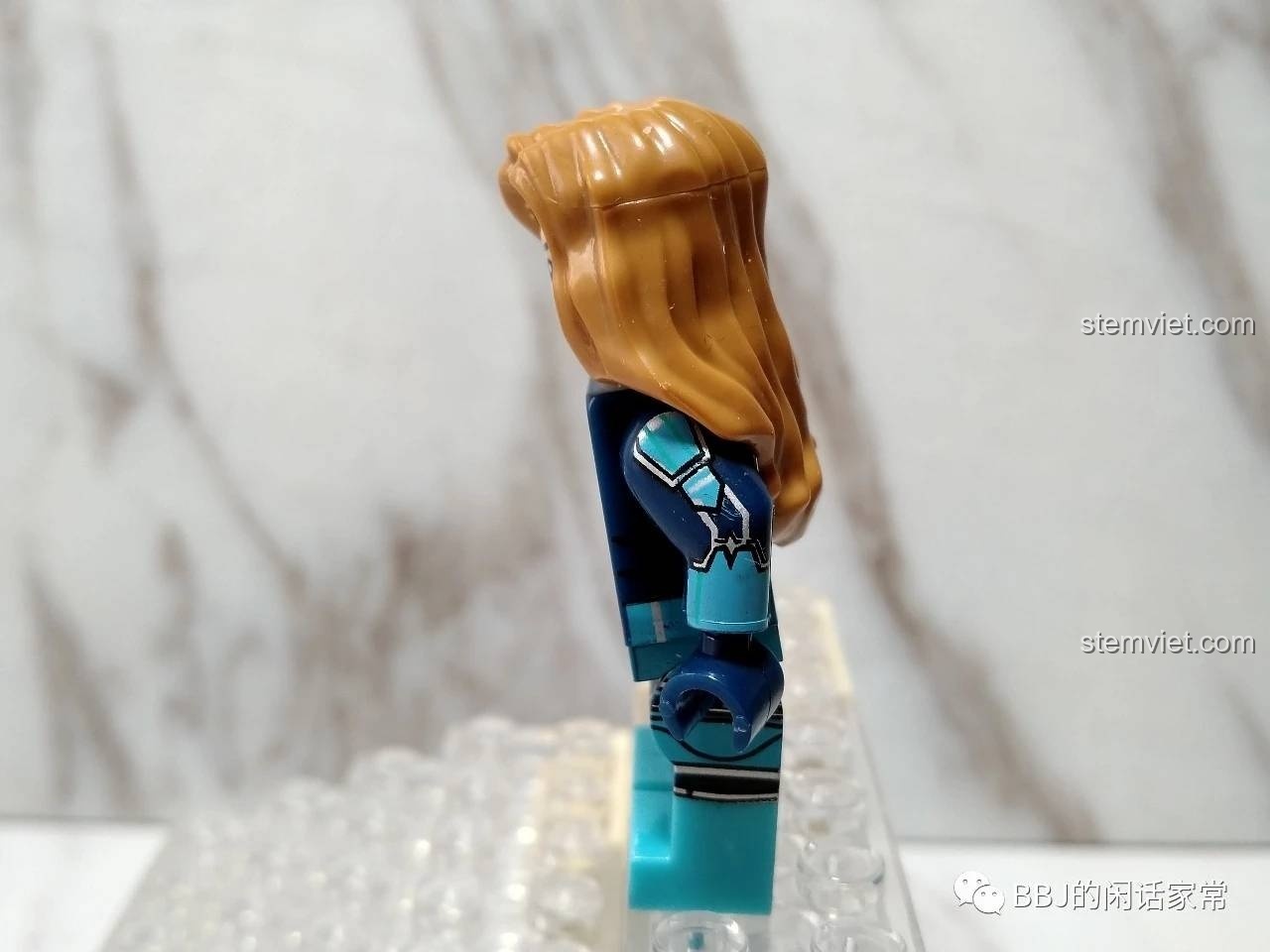 Ảnh chụp bên hông của đồ chơi mô hình Minifigure Captain Marvel XINH, thể hiện chi tiết in trên cánh tay.