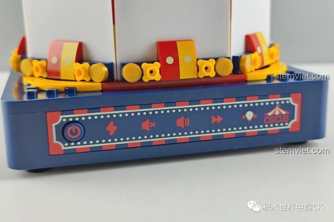 Cận cảnh bảng điều khiển trên đế hộp nhạc JAKI JK1366, với các nút chức năng bật/tắt, điều chỉnh âm lượng và chế độ đèn. Đánh giá JAKI 1366 Vòng quay ngựa gỗ phát sáng.