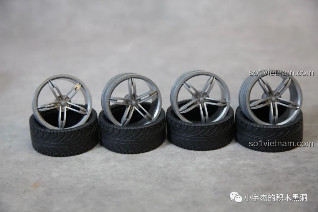 Bốn bánh xe với lốp cao su và vành đúc màu bạc của mô hình McLaren Senna GTR 673002.