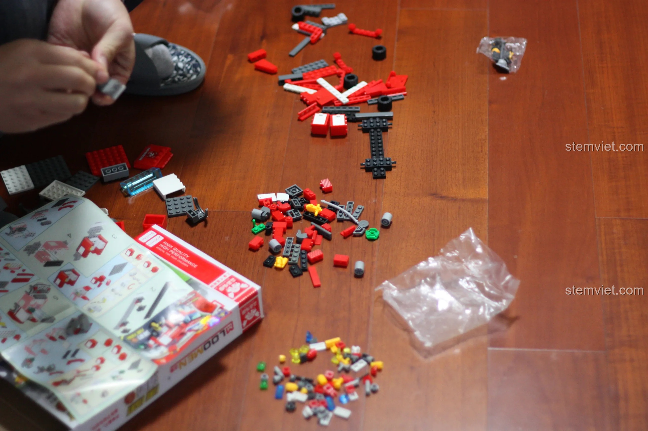 Quá trình lắp ráp bộ đồ chơi xếp hình Xe PCCC KY8054 bắt đầu với các chi tiết được đổ ra sàn nhà.