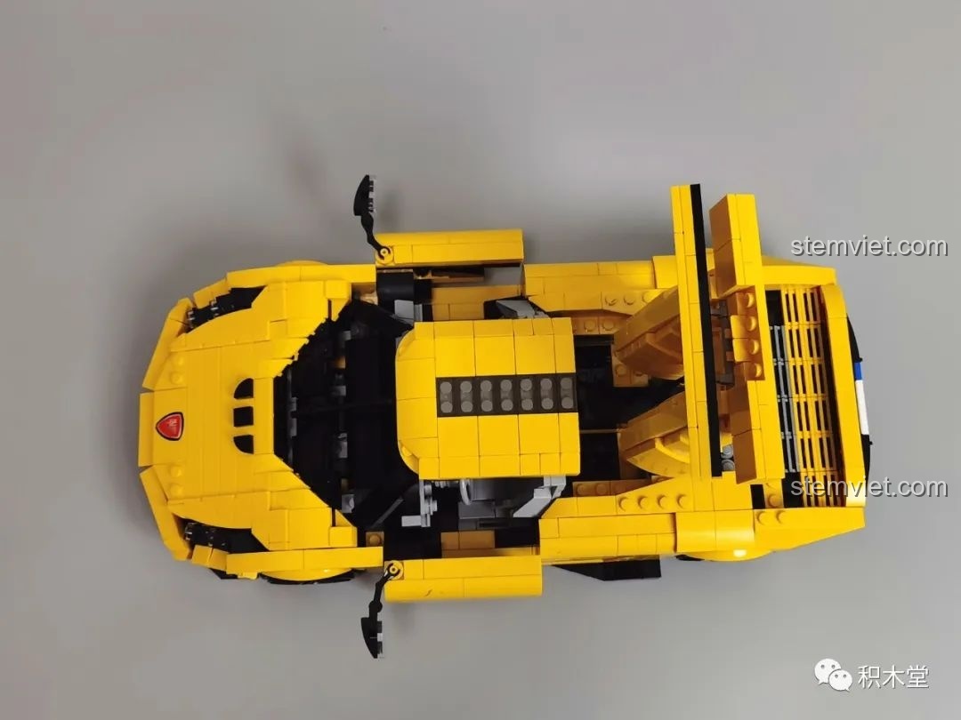 Nhân vật Batman ngồi trong xe mô hình Lego Koenigsegg Regera màu vàng.