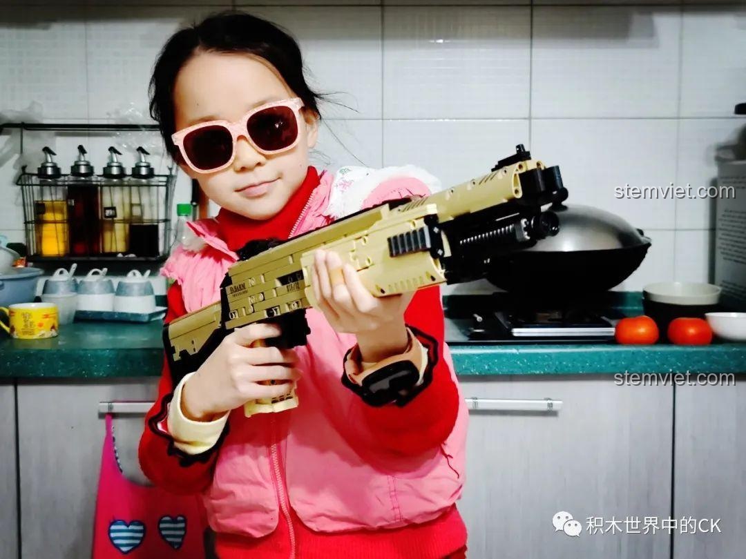 Cận cảnh bé trai cầm mô hình súng shotgun STF-12 JIESTAR 92402, thể hiện kích thước phù hợp với tay trẻ em.