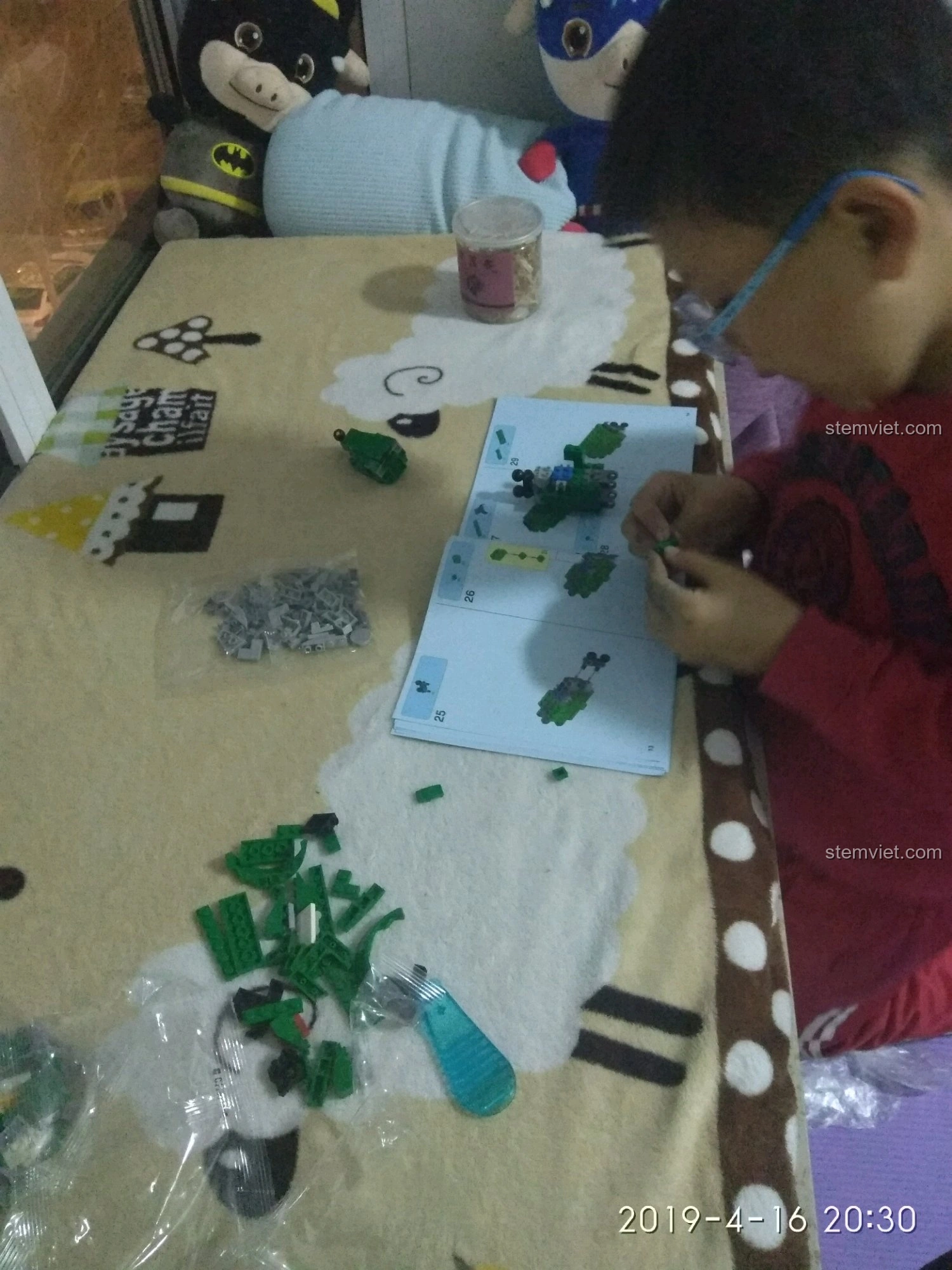 Bé trai đang lắp ráp chú sư tử số 5 từ bộ Đế Trưng Bày Voltron Bách Thú Vương SY 1130.