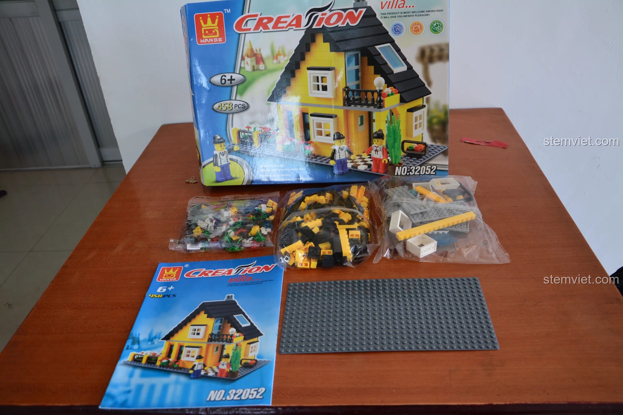 Các thành phần bên trong hộp WANGE 32052, bao gồm túi mảnh ghép, sách hướng dẫn và đế lắp ráp nhỏ.