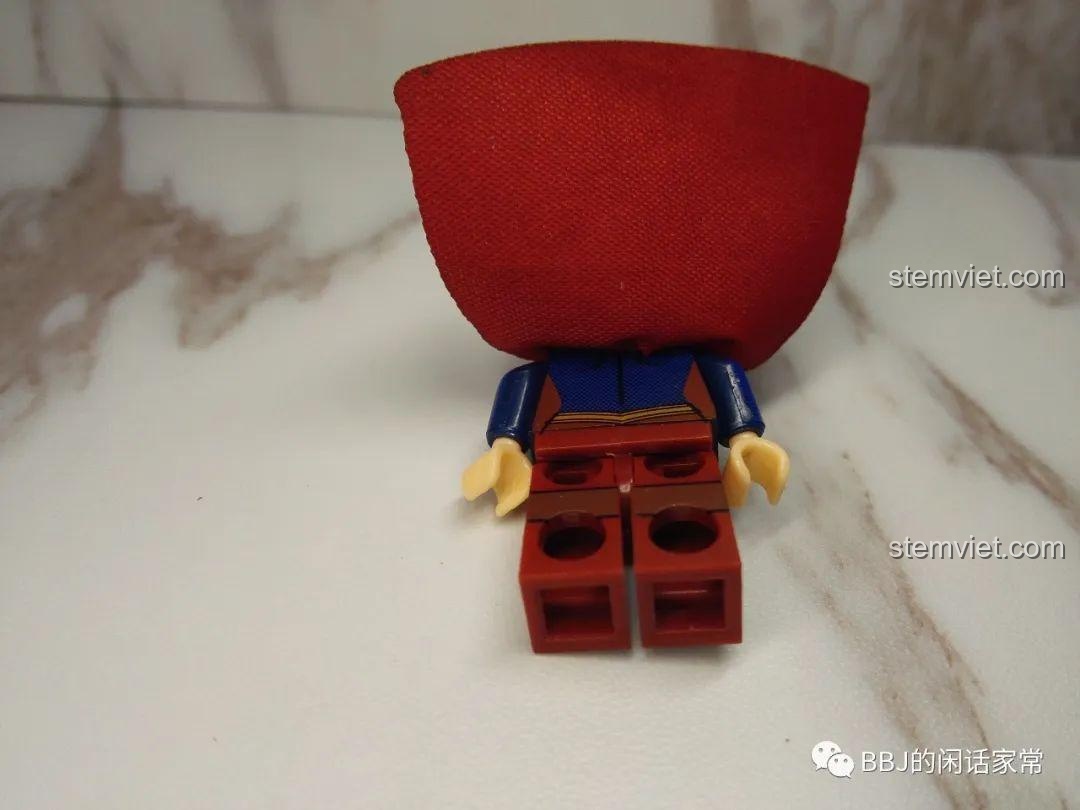 Mô hình Supergirl (Siêu Nữ) từ phía sau, nổi bật với áo choàng đỏ.