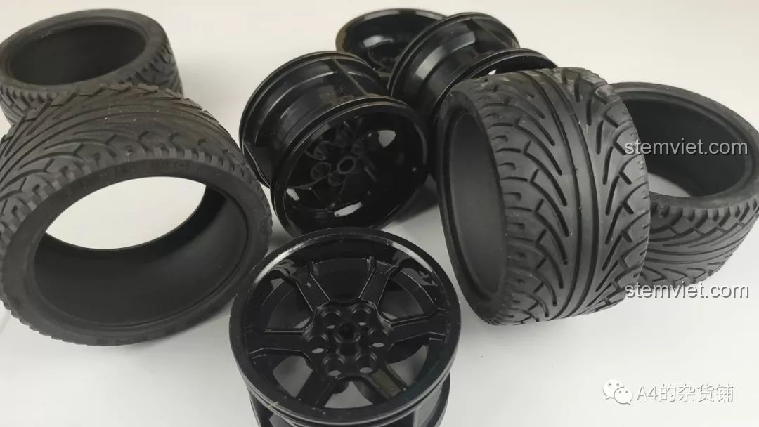 Cận cảnh bộ bốn bánh xe với vành đen bóng và lốp cao su có vân của mô hình CaDA C61016.