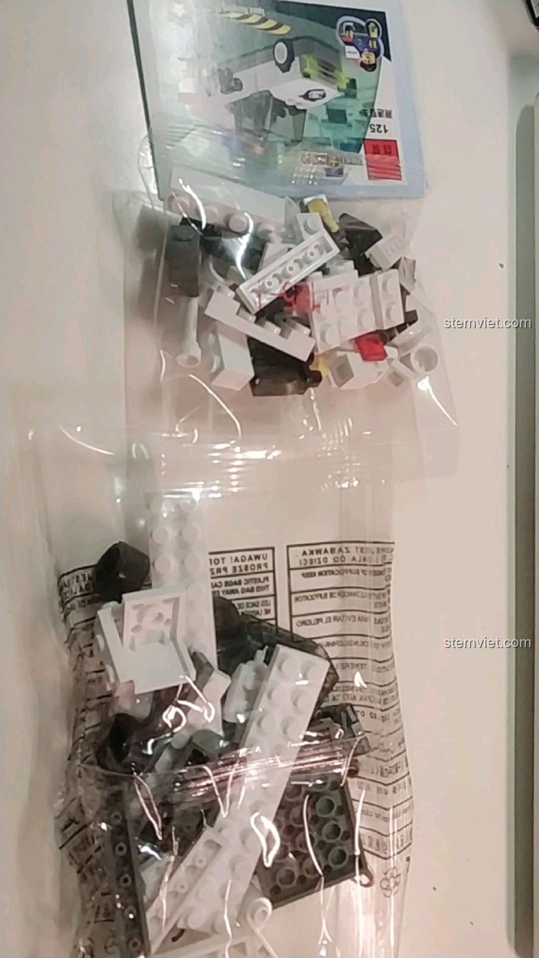 Các túi mảnh ghép và tờ hướng dẫn bên trong hộp bộ đồ chơi Xe cảnh sát giao thông cho bé trên 6 tuổi.