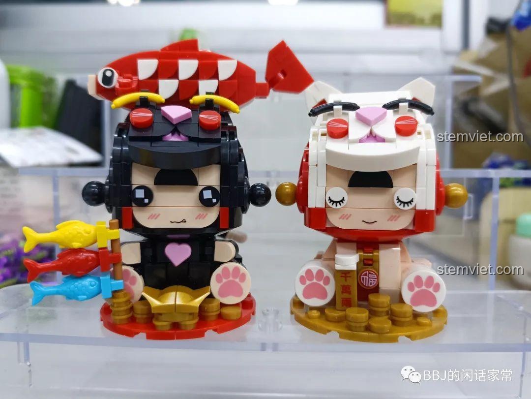 Bộ đôi mô hình lắp ráp Xiao Meng Ji 2053 Mèo Thần Tài và 2054 Cô Bé Mèo Cá Koi đứng cạnh nhau, một sự kết hợp hoàn hảo.