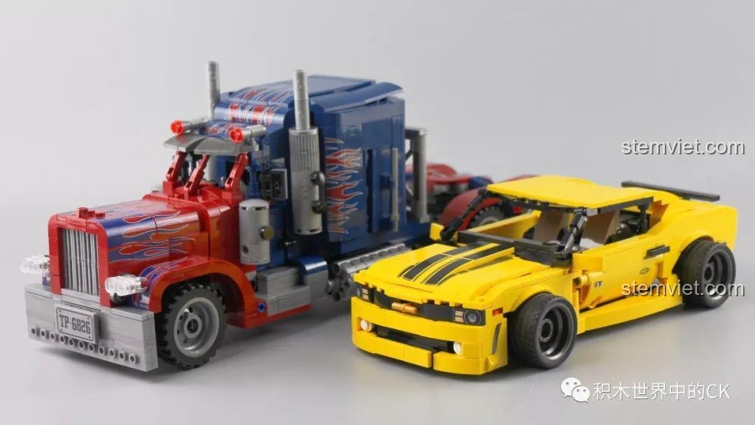 Mô hình xe Bumblebee SEMBO 701504 đặt cạnh một mô hình xe tải Optimus Prime, tạo thành bộ đôi hoàn hảo.