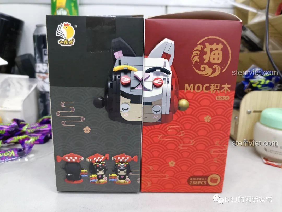 Hai hộp đồ chơi lắp ráp Xiao Meng Ji 2053 Mèo May Mắn và 2054 Cô Bé Mèo Cá Koi đặt cạnh nhau, thể hiện thiết kế đối xứng.
