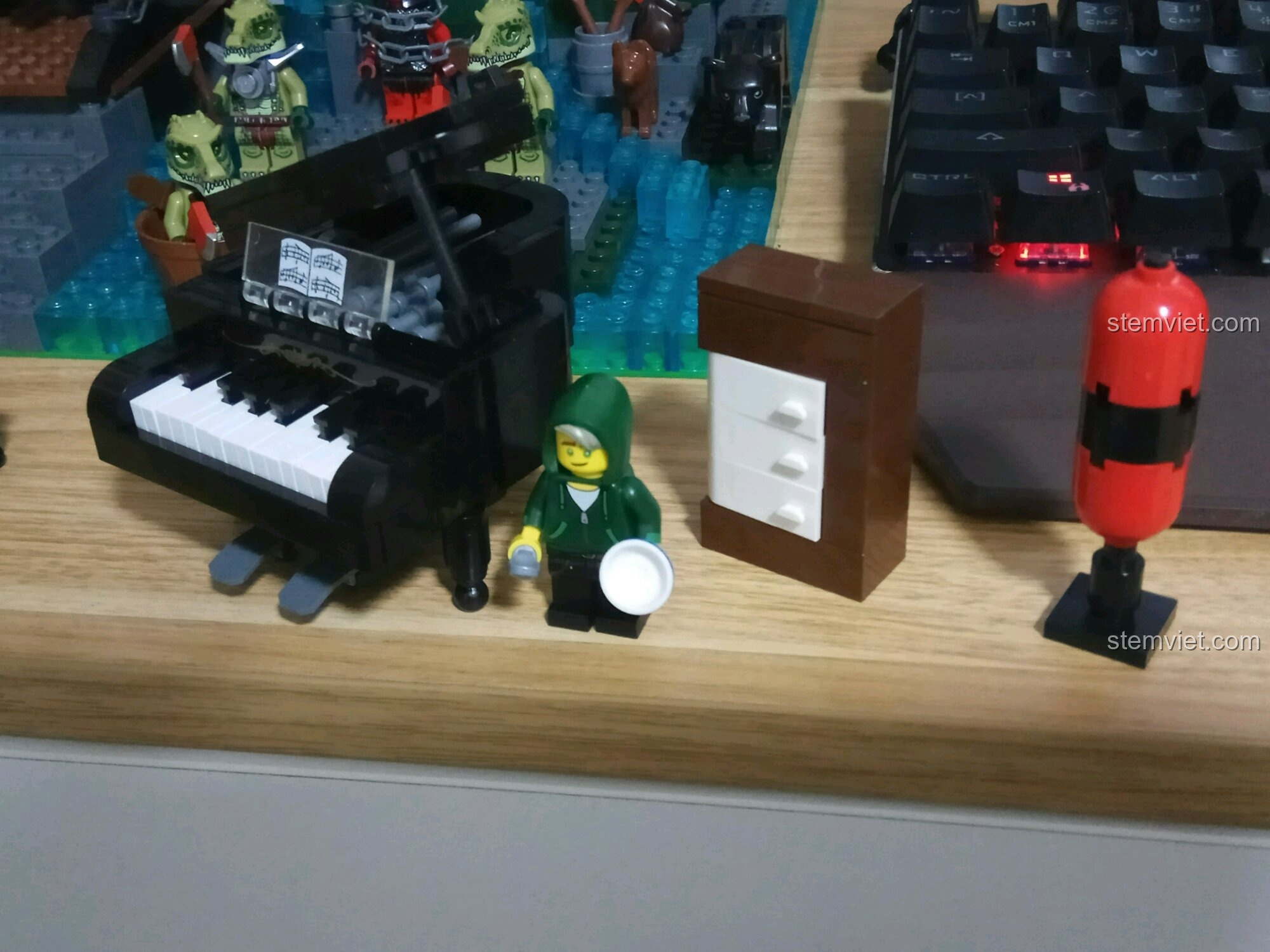 Góc nhìn cận cảnh bộ lắp ghép Đàn Dương Cầm Cổ Điển QMAN 411 cùng người chơi và các chi tiết phụ, tạo nên một bối cảnh sống động.